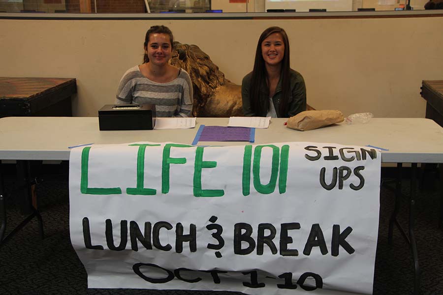 Kaylee Combs, senior, and Abby Gross, freshman, hold sign-ups for Life 101 in the library. “Life 101” will be held on Friday, Oct. 10 from 9 a.m. to noon. 