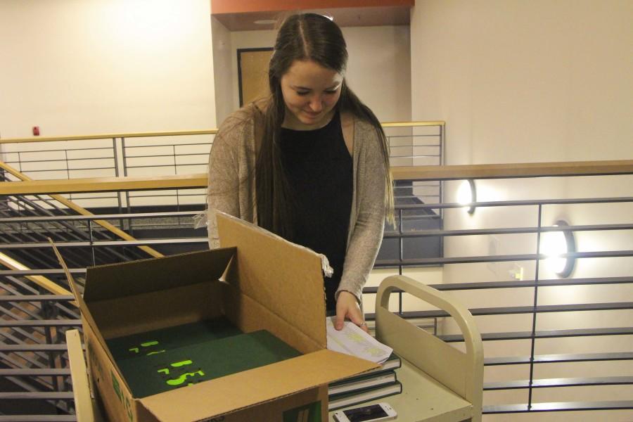 Jillian Emken, junior, hands Bryan Chapman, freshman, his yearbook. The 2015 Green and Gold yearbook is 220 full color pages and features a different design concept in each section. 