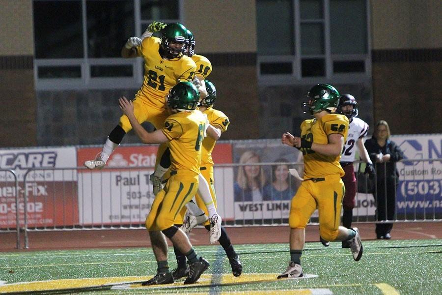 After scoring a touchdown, Qawi Ntsasa, sophomore, celebrates with his teammates. Ntsasa scored the first two touchdowns for West Linn and helped his team win 49-35.
