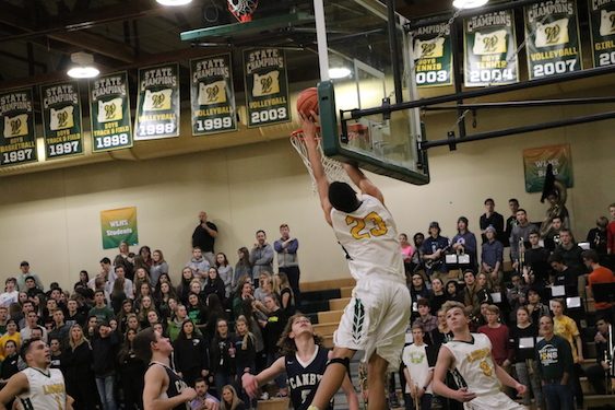 Khalid Thomas, senior forward, finishes with authority in a 88-44 win against Canby. 
