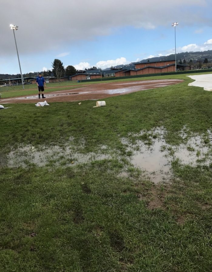 A grounds crew member surveys the field conditions at Newberg High School before going to work.