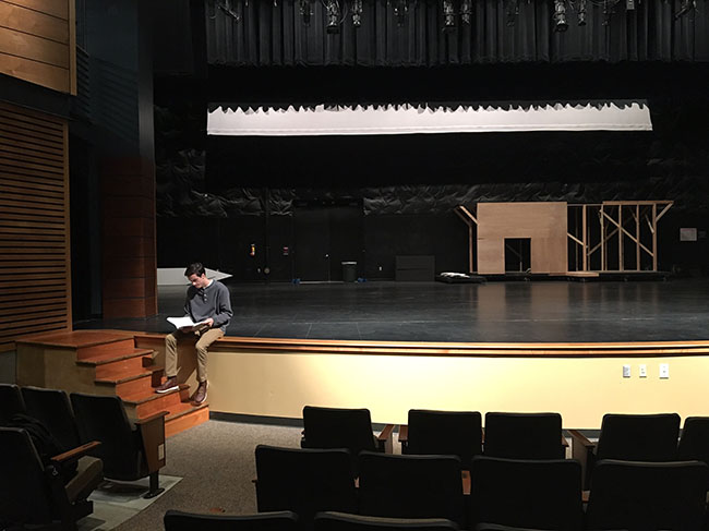 Awaiting the rest of his cast members, Matthew Lewis, senior, reads through his lines before the musical’s daily rehearsal. This year’s musical “Spamalot,” will premiere Nov. 2 in the Performing Arts Center.