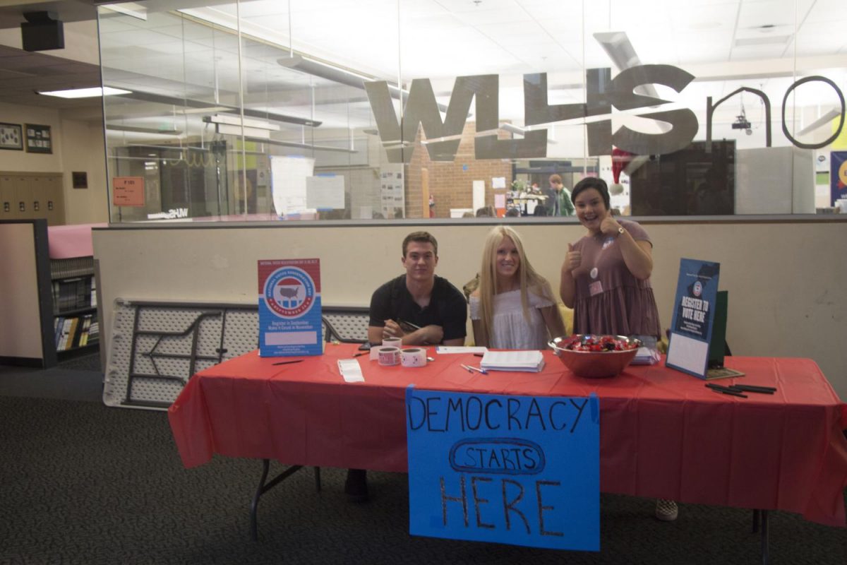 Students working with the Bus Project, armed with stickers and candy, await eager voters-to-be. From left to right: Zack Huffstutter, senior; Haley Thayer, senior; Skylar Kool, senior.