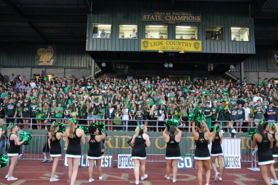 Leading the student section in cheers as the football team plays against South Medford, the cheerleaders are able to show off their game routines. This past weekend, however, the team made their transition to their competitive season with a second place finish at their league competition.