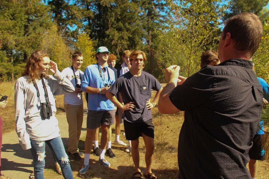 On a shuttle field trip to Browns Ferry Park in Tualatin, the AP Environmental Science class learns about native plants. Jim Hartmann, AP Envi Sci teacher, hold up a plant the students are trying to identify. The class is in a plant and bird identification unit and takes to the outdoors to learn plant and bird names.