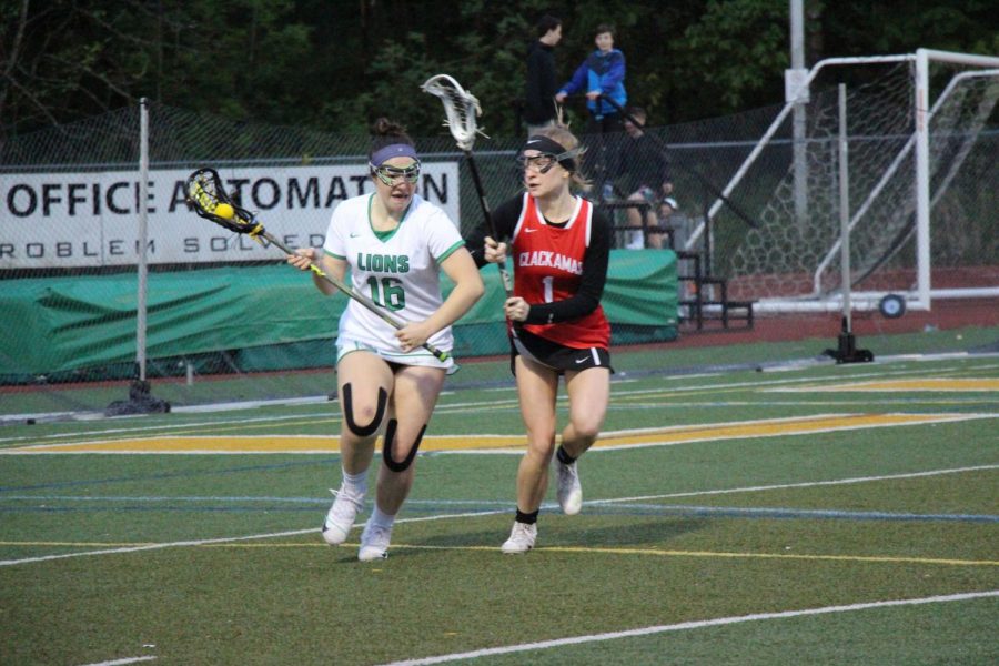 After getting the ground ball, senior Abby Manley makes her way up the field past Clackamas attackman.