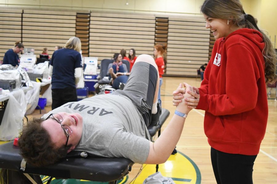 Before he gives blood, Tucker Parrish holds Katy Bruins hand. 