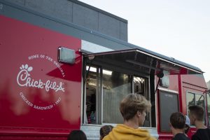 At the first football game of the season, students, parents, and staff alike wait in line at the Chick-fil-A food truck.  