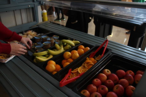 Students filling their trays at the fruit cart in the cafeteria. These carts are available everyday during lunch.