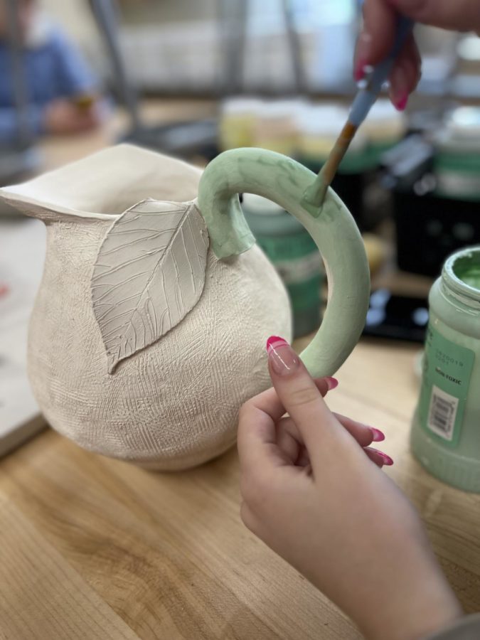 After going through the firing process, Sam Wilson, junior, glazes her piece by hand. During fourth period AP 3D-Design, Wilson has focused her portfolio around function items with a special interest on pitchers, vases and teapots. In her most recent project she has taken inspiration from a lemon as she replicates the texture and color scheme into her artwork. 