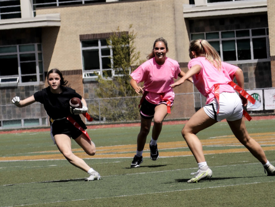 Left in the dust. While an offensive play occurs, Kylee Shreck, freshman, runs the ball down the sideline with the pink team fresh on her heels. Schreck scored a touchdown before while playing against the blue team, proving herself a key addition to the black team.