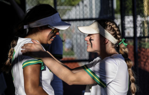 In the dugout, Gomez embraces Rylee Gaustad, junior, after the celebration. The softball team played the Lakeridge Pacers at 6:45 p.m. and lost 7—5. 