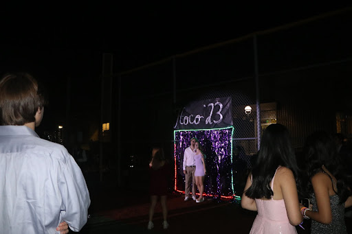 Students pose at a picture station provided by ASB. Spotlights shone from behind the refreshment station to light the station up.