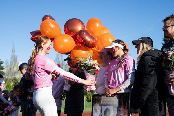 Before the game against the Lakeridge Pacers, Brooke hands Curtis family flowers to recognize a family friends leukemia diagnosis.