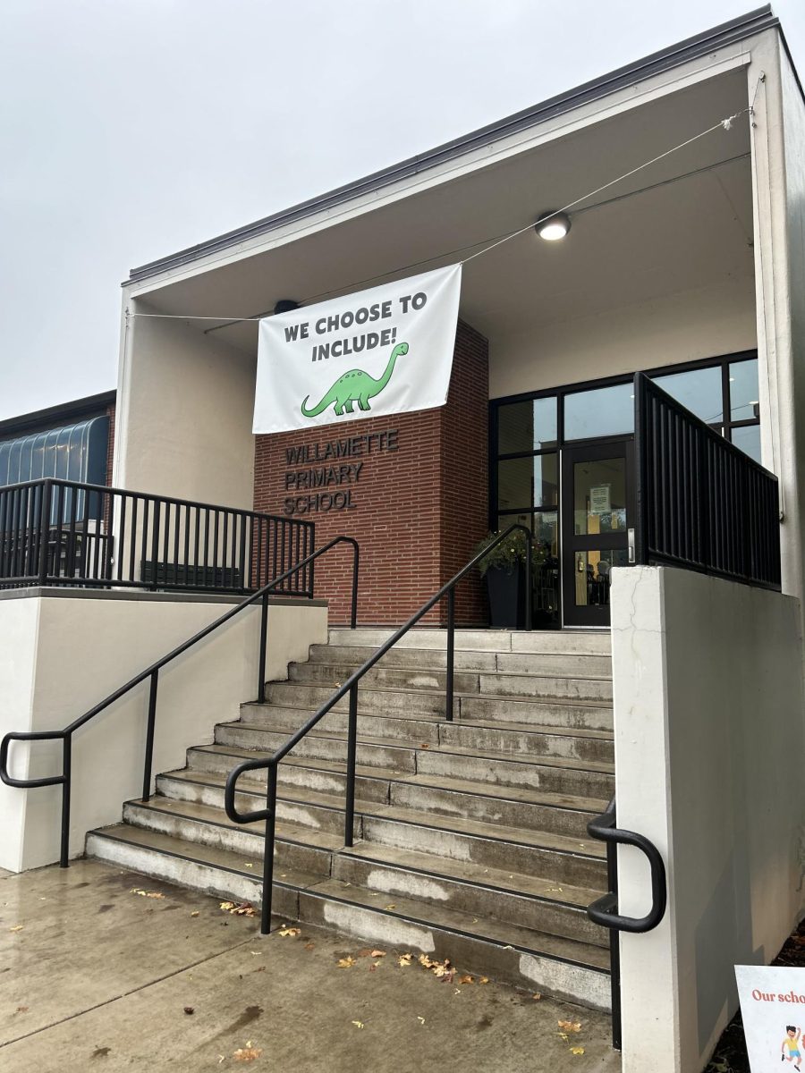 Above the recently renovated front entrance of one of West Linn-Wilsonville's elementary schools, Willamette Primary School, the meaningful mascot "Douglasaurus" is displayed highlighting an inviting message on a welcome banner.