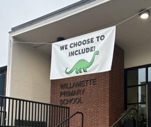 Above the recently renovated front entrance of one of West Linn-Wilsonville's elementary schools, Willamette Primary School, the meaningful mascot "Douglasaurus" is displayed highlighting an inviting message on a welcome banner.