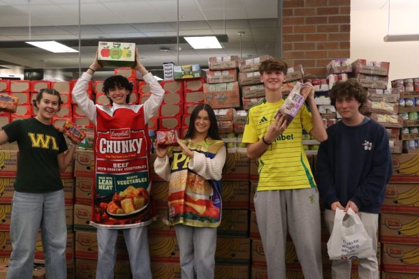 Time to celebrate. The Associated Student Body (ASB) stood with the completed collection of canned foods from the campus food drive before donating to the West Linn Food Pantry. This school year, a new record of 6,817 cans were donated. 