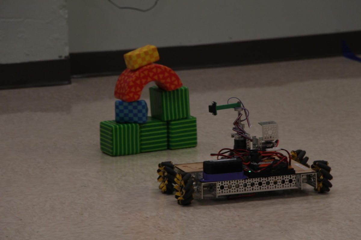 Full speed ahead. A robot heads towards the direction of stacked foam blocks set by one of the younger students. The robots were all made and programmed by the robotics team, FRC 7034.