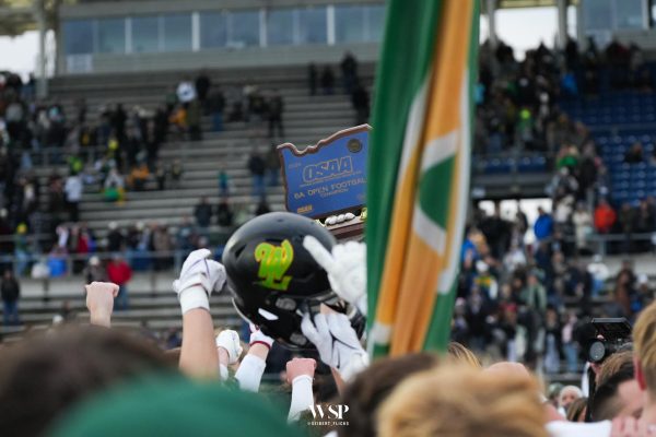 West Linn football players gather around to lift the 2024/25 OSAA 6A State Championship title.