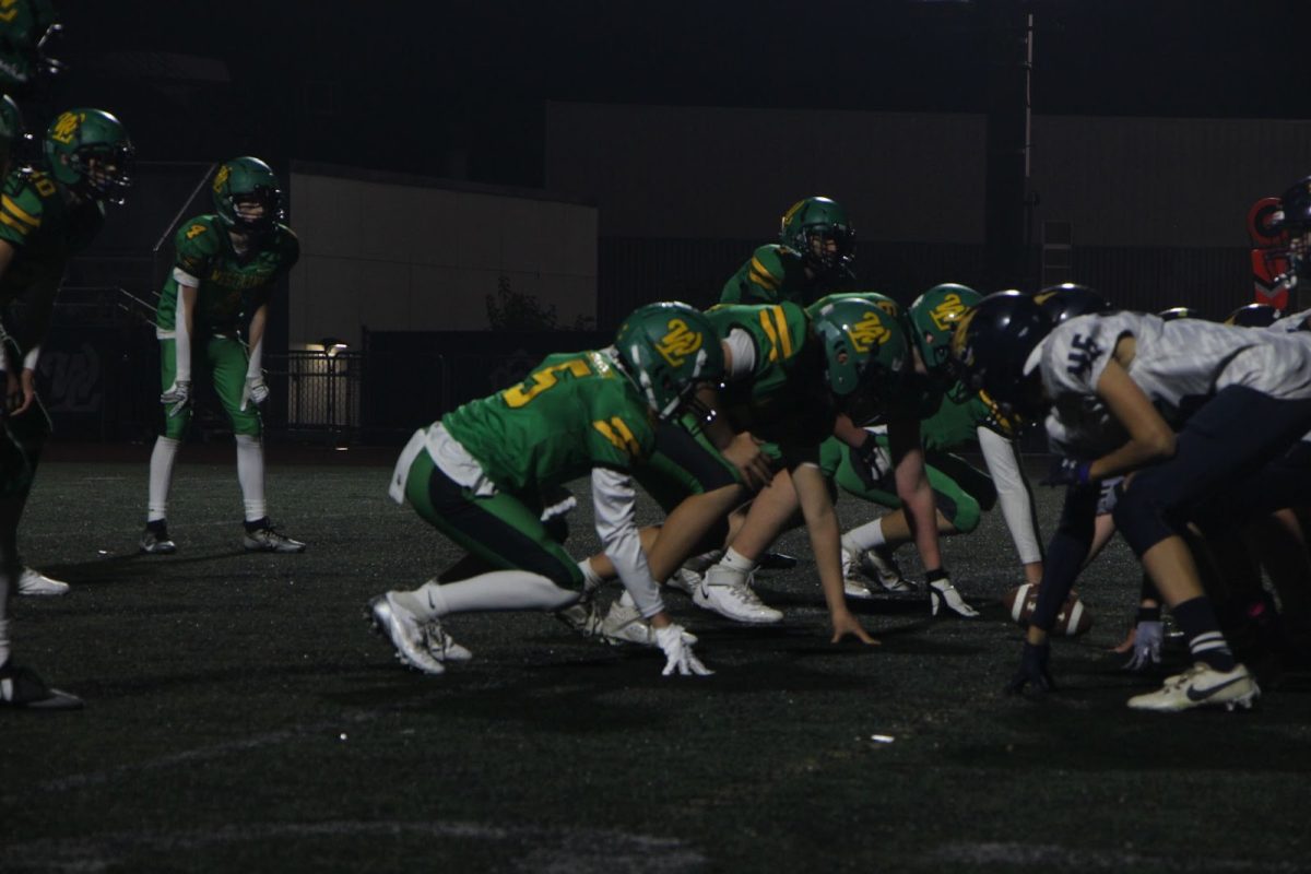 Bring it on. Players line up on the field, getting ready for the next play. They stand face to face with the opposing team: the Tigard Tigers.