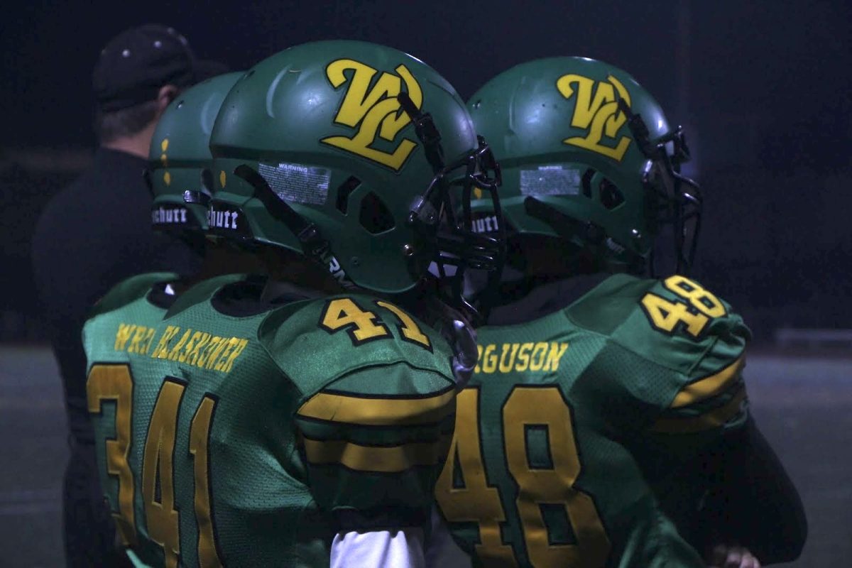 Owen Ferguson, Nolan Wright, and Escher Blaskower stand together dressed in green and gold, ready to represent their team. On Fridays, the players wear their jerseys to school to represent their team pride. 