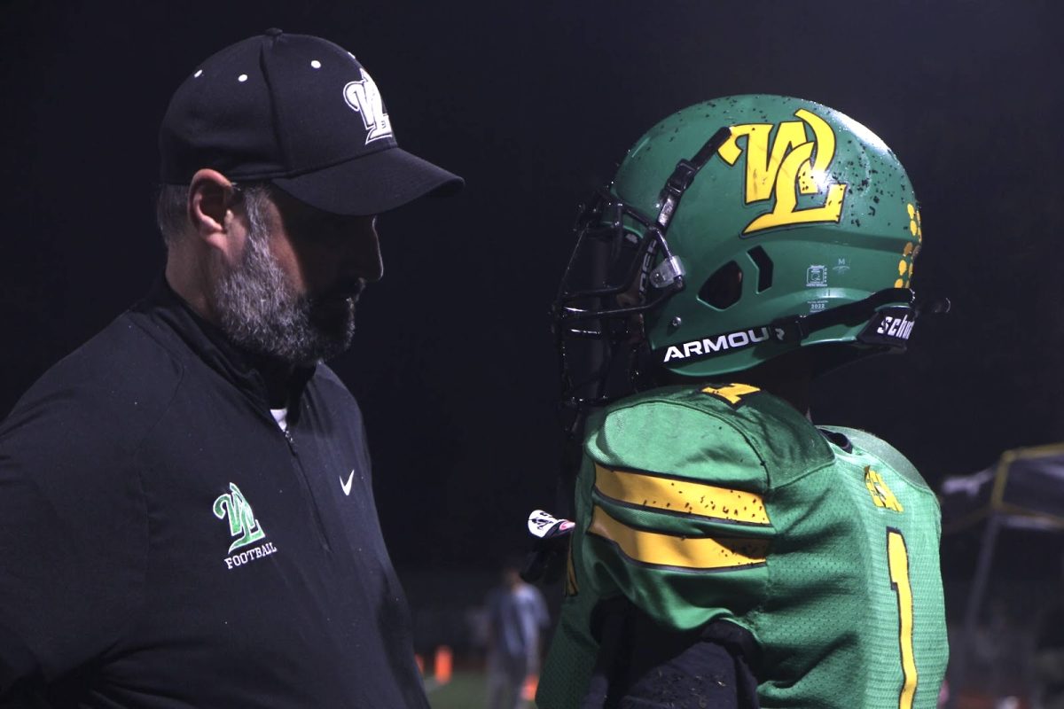 Press pause. Luis Vega, tight end and linebacker, talks with Head Coach Cameron Reynolds during a timeout. The assistant coach for the team is Andrew Baltz, whose son is a senior at West Linn High School and is on the varsity football team. 