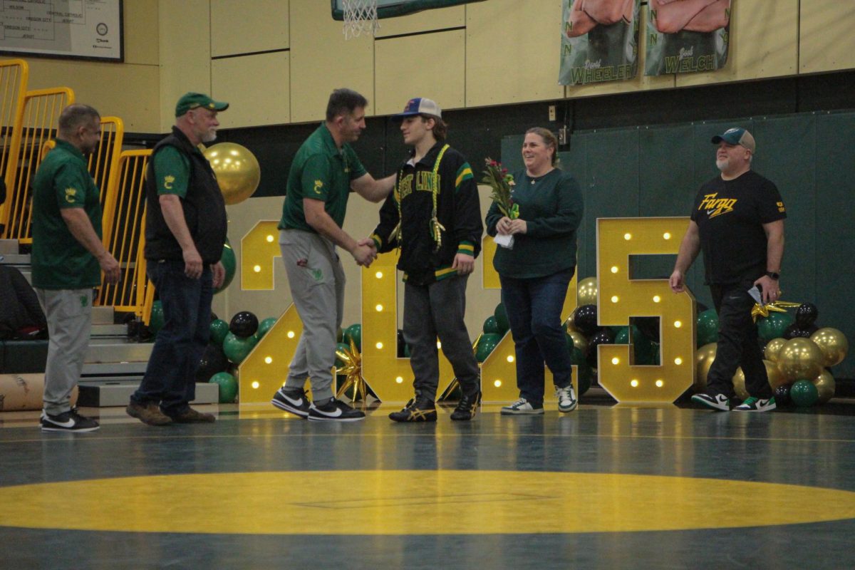 Michael Smith, senior, shakes Coach Kevin Keeney's hand during senior night ahead of the match against the Harrisburg Eagles.