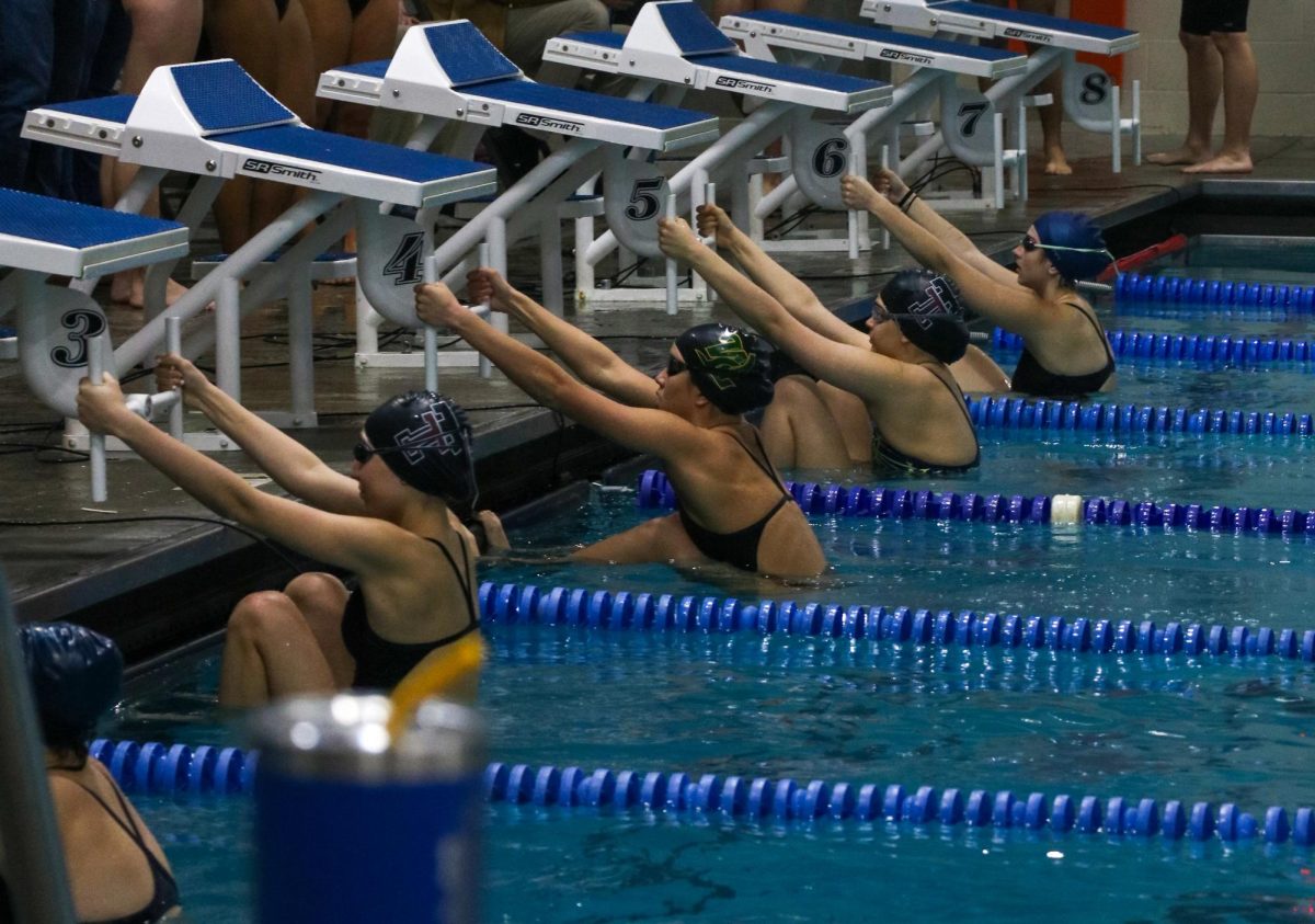 Swimmers get in position to start their race at the Tualatin meet on Dec. 19, 2024.