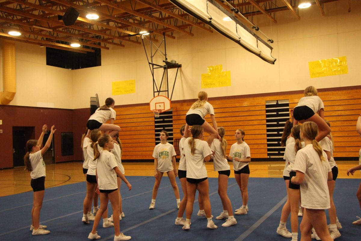 Hitting their stunts. The junior cheerleaders start to warm up their stunts. Olivia Orth, Grace Thaut, Lillie Mae Summers, and Macall Fox are some of the 20 athletes on the competition team this year with four stunt groups. The team is moving categories due to the size of their roster.. “One challenge this year is moving up from the medium rec category, we competed in last year, to large rec category,” Jorgensen said.