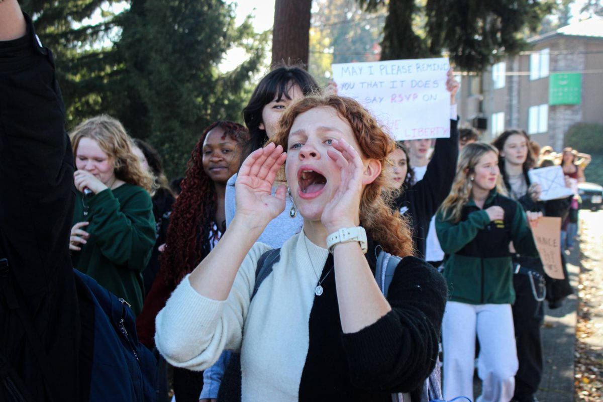 Eloise Guarisco, senior, leads a chant as the group continues walking away from the school.