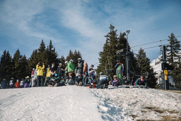 Ahead of practice, the snowboarding team waits at the top of the mountain, preparing to go down.